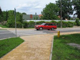 Skrzyżowanie z wyniesioną nawierzchnią - wymusza na pojazdach zmniejszenie prędkości, a dodatkowo niweluje dla pieszych konieczność schodzenia do poziomu jezdni